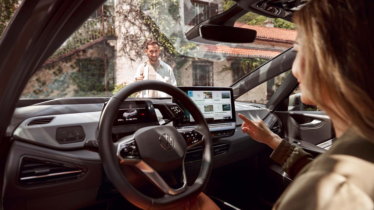 Ženska, ki uporablja aplikacijo In-Car Servis vozila v infotainment sistemu VW