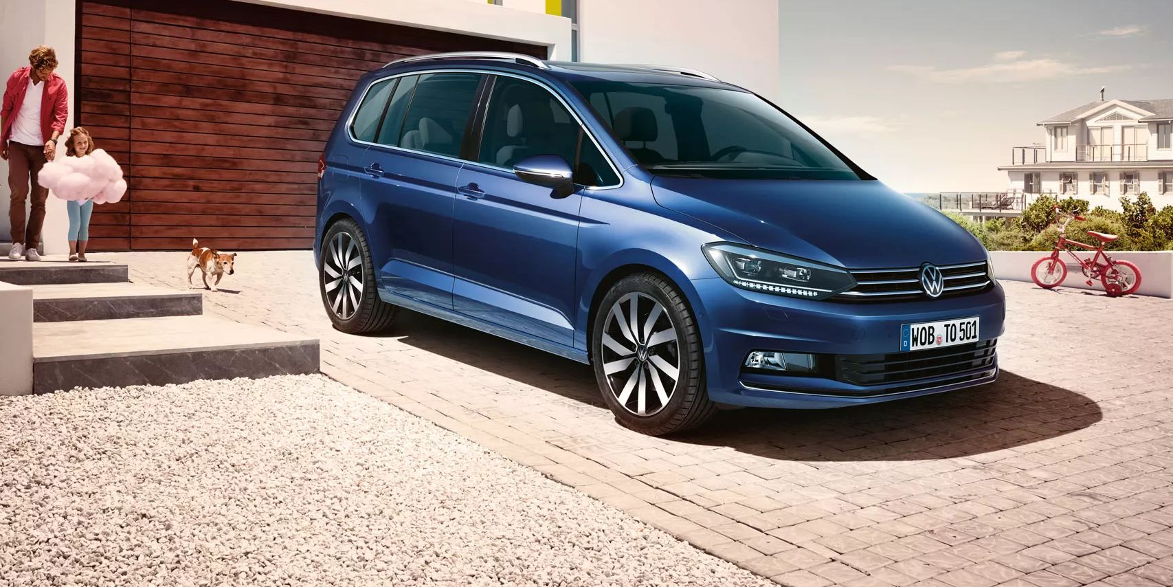 Modri VW Touran parkiran pred enodružinsko hišo