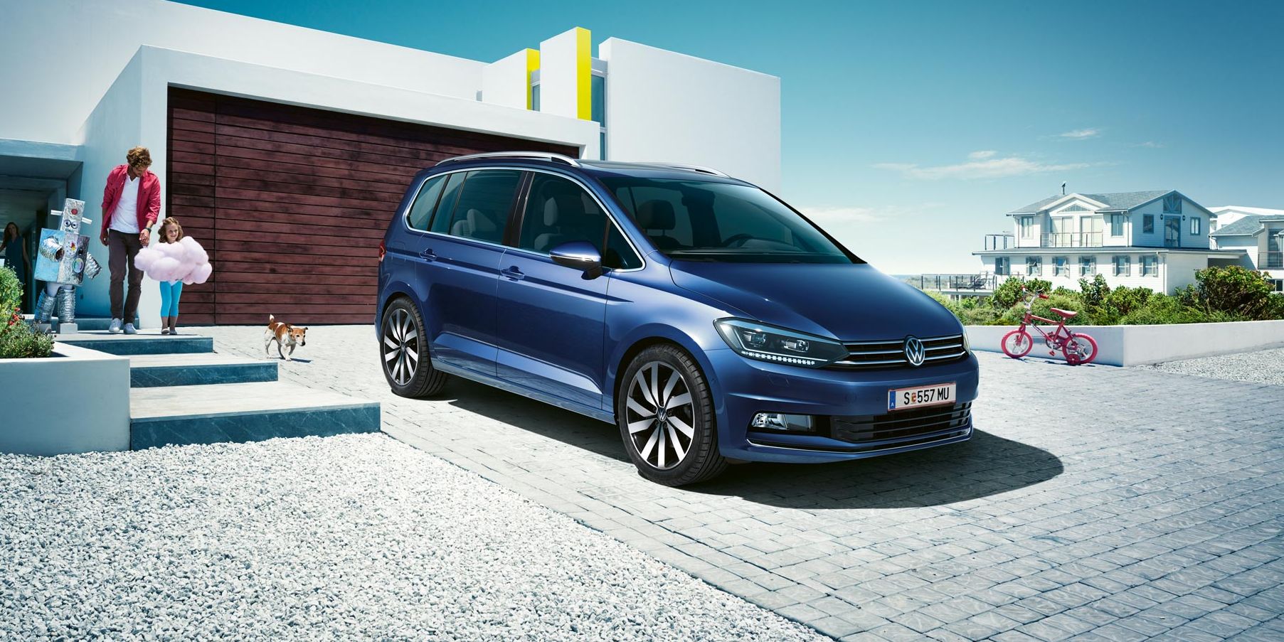 Modri VW Touran parkiran pred enodružinsko hišo