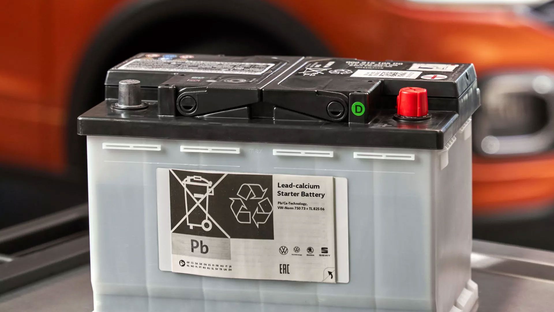 Akumulatorska baterija. V ozadju je oranžen Volkswagen T-Cross.