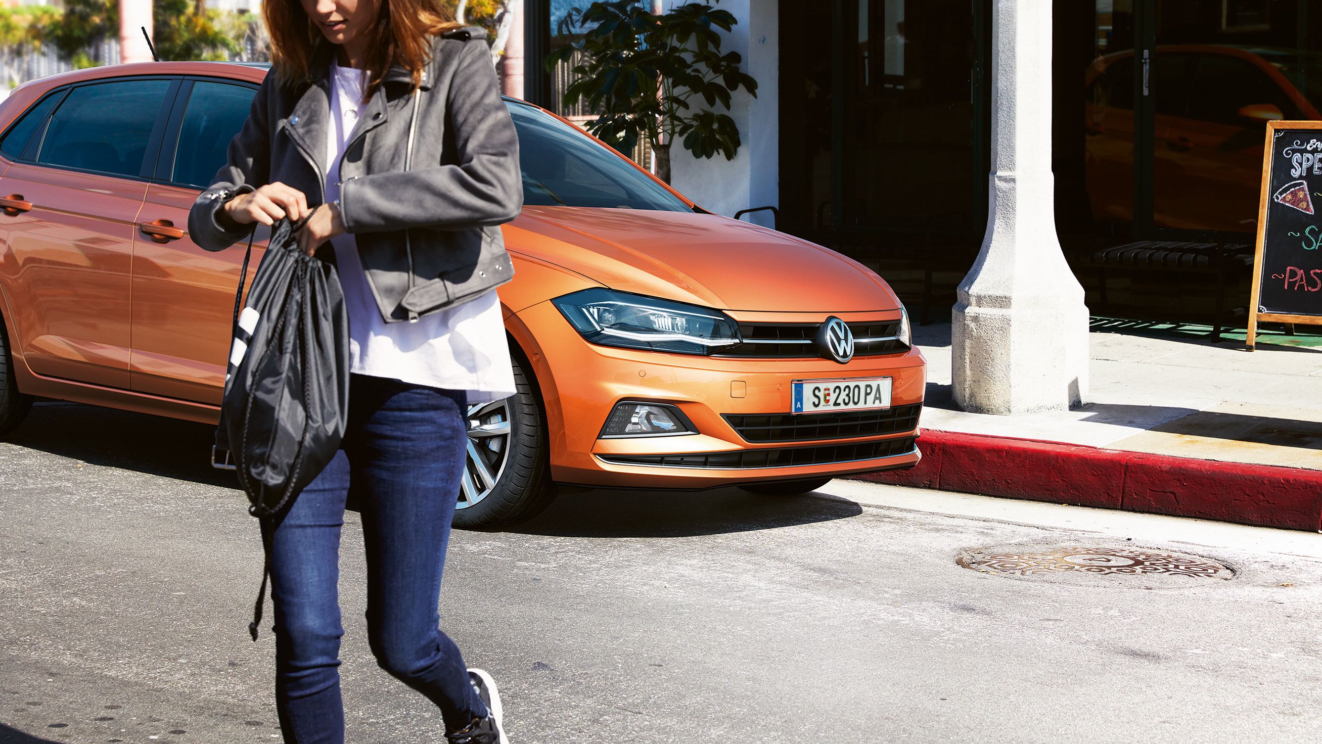 VW Polo oranžna sprednji del z žensko