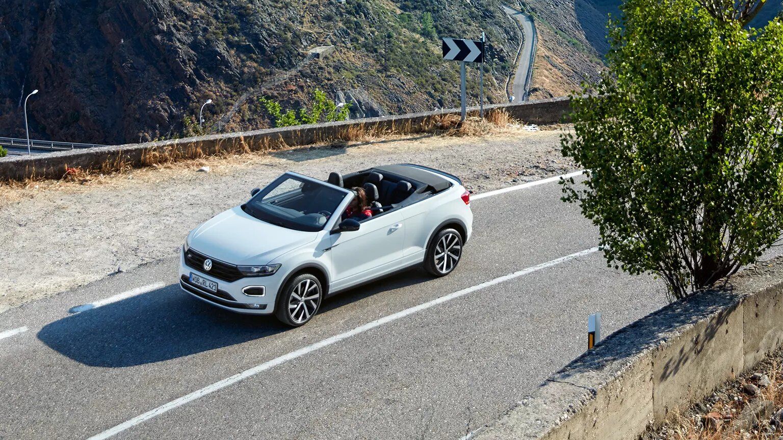 VW T-Roc Cabriolet vozi po regionalni cesti.
