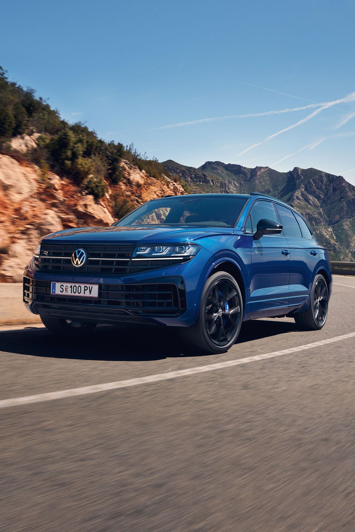 Touareg R eHybrid znamke VWR vozi skozi ovinek, v ozadju gore