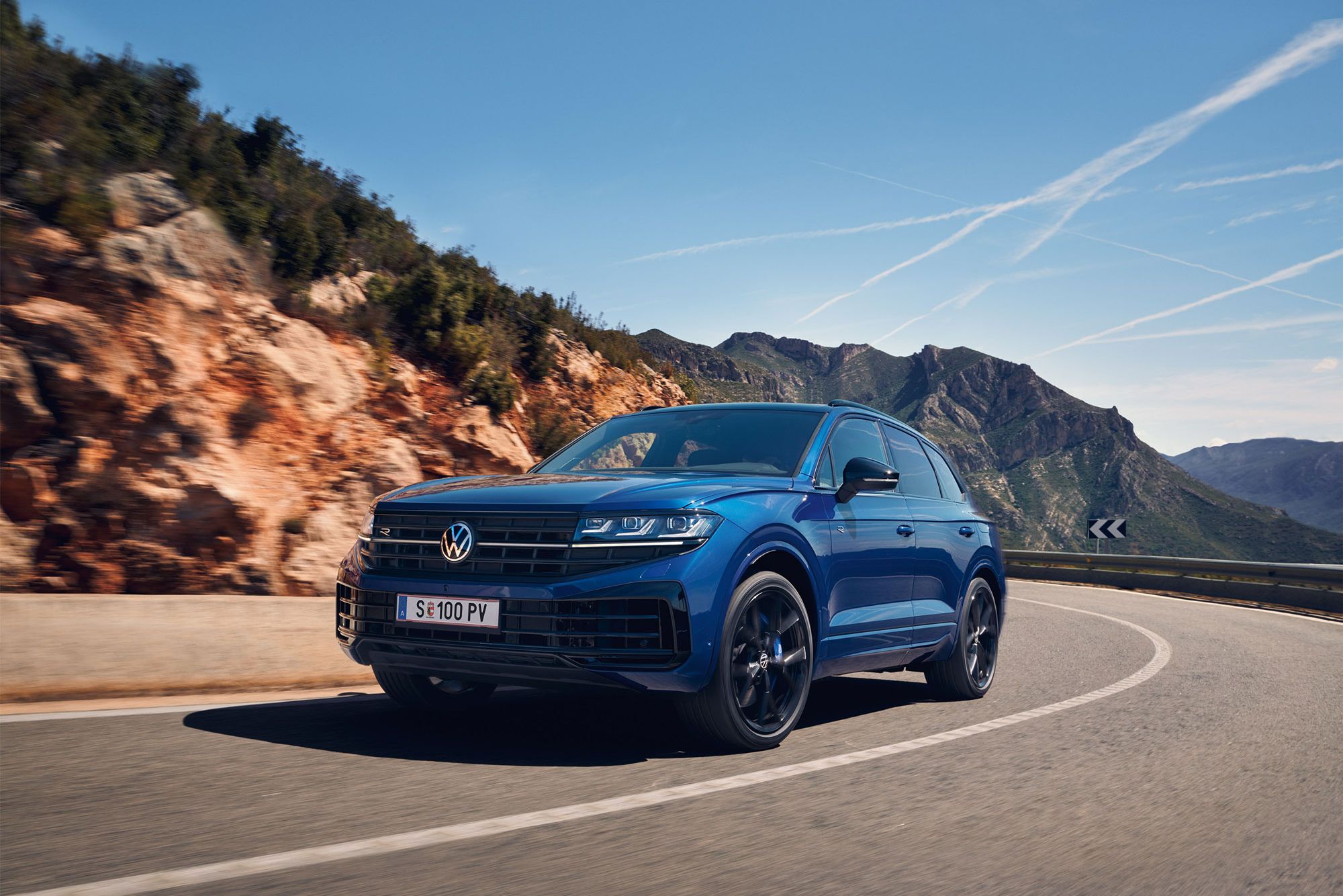 Touareg R eHybrid znamke VWR vozi skozi ovinek, v ozadju gore