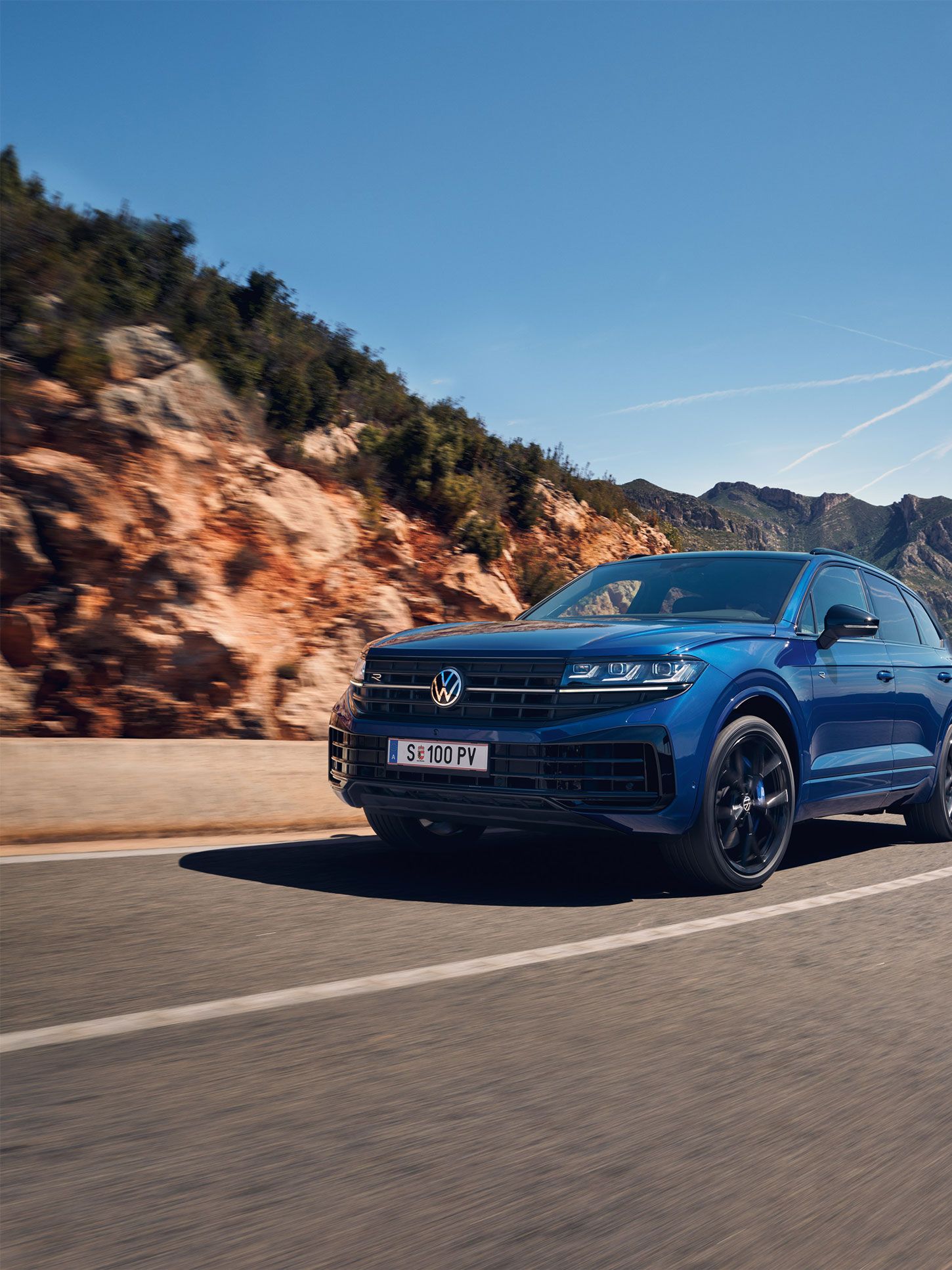 Touareg R eHybrid znamke VWR vozi skozi ovinek, v ozadju gore