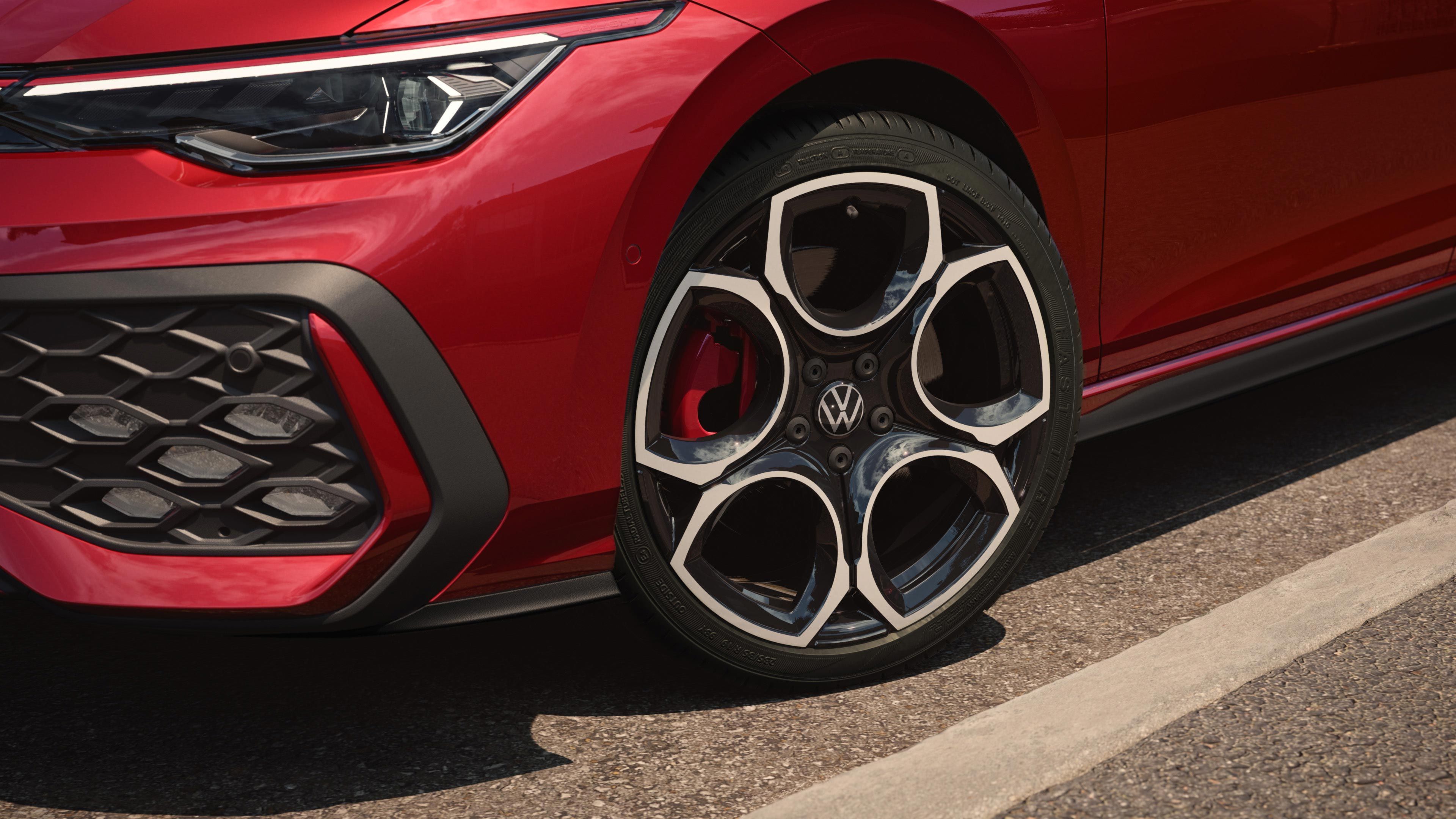 Bližnji posnetek platišča pri rdečem VW Golfu GTI.