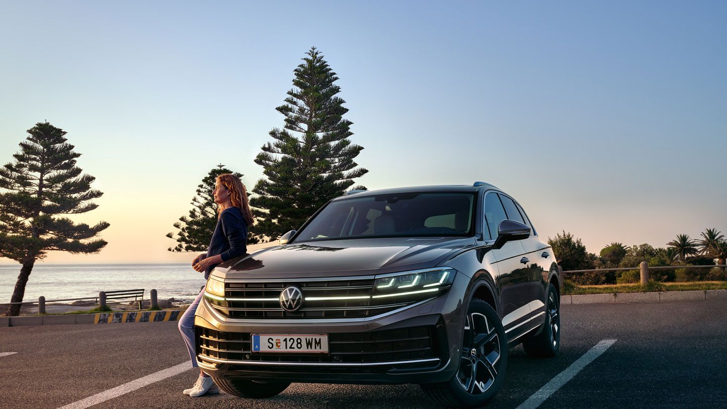 VW Touareg Elegance ob mraku ob morju z vklopljenimi žarometi HD Matrix.