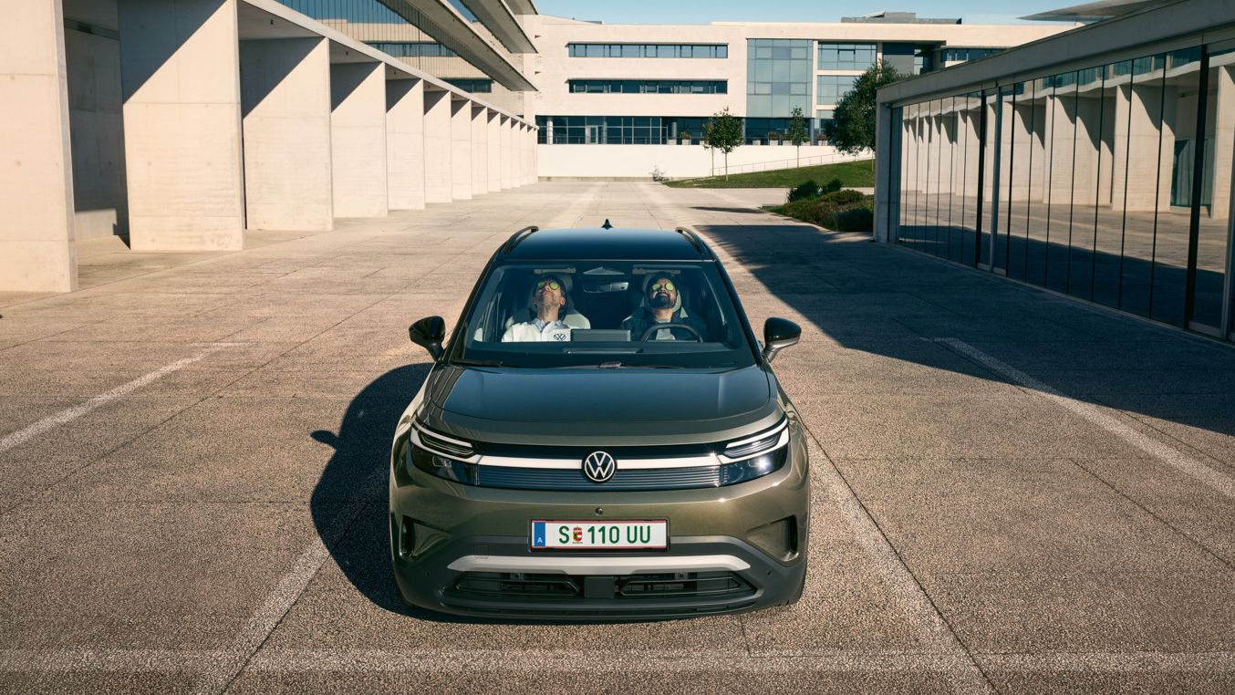 Dva moška sedita udobno naslonjena na sprednjih sedežih VW ID. Crossa in imata zaprte oči. 