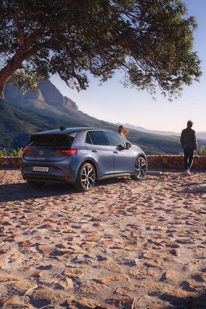 Modri VW ID.3 Neo je parkiran na parkirišču v gorah, ženska in moški uživata v razgledu