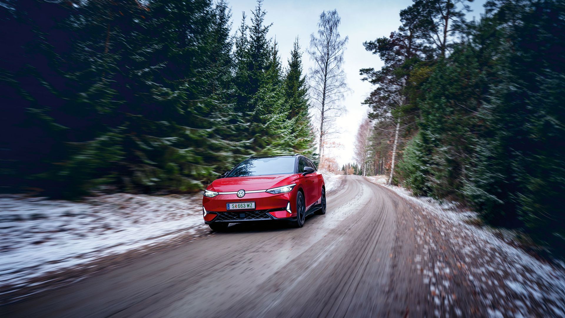 Rdeč VW ID.7 GTX Tourer vozi po cesti.