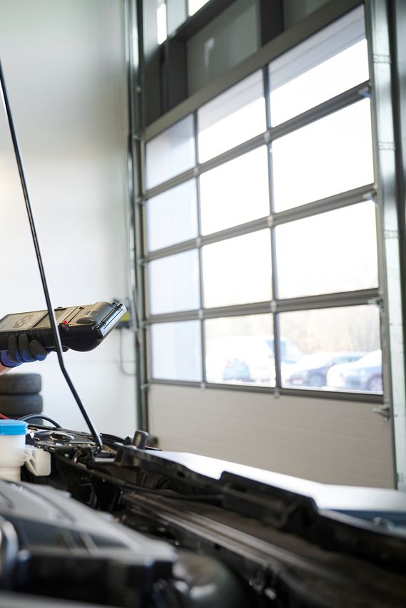 Eine Volkswagen Mechanikerin überprüft die Batterie eines Volkswagen