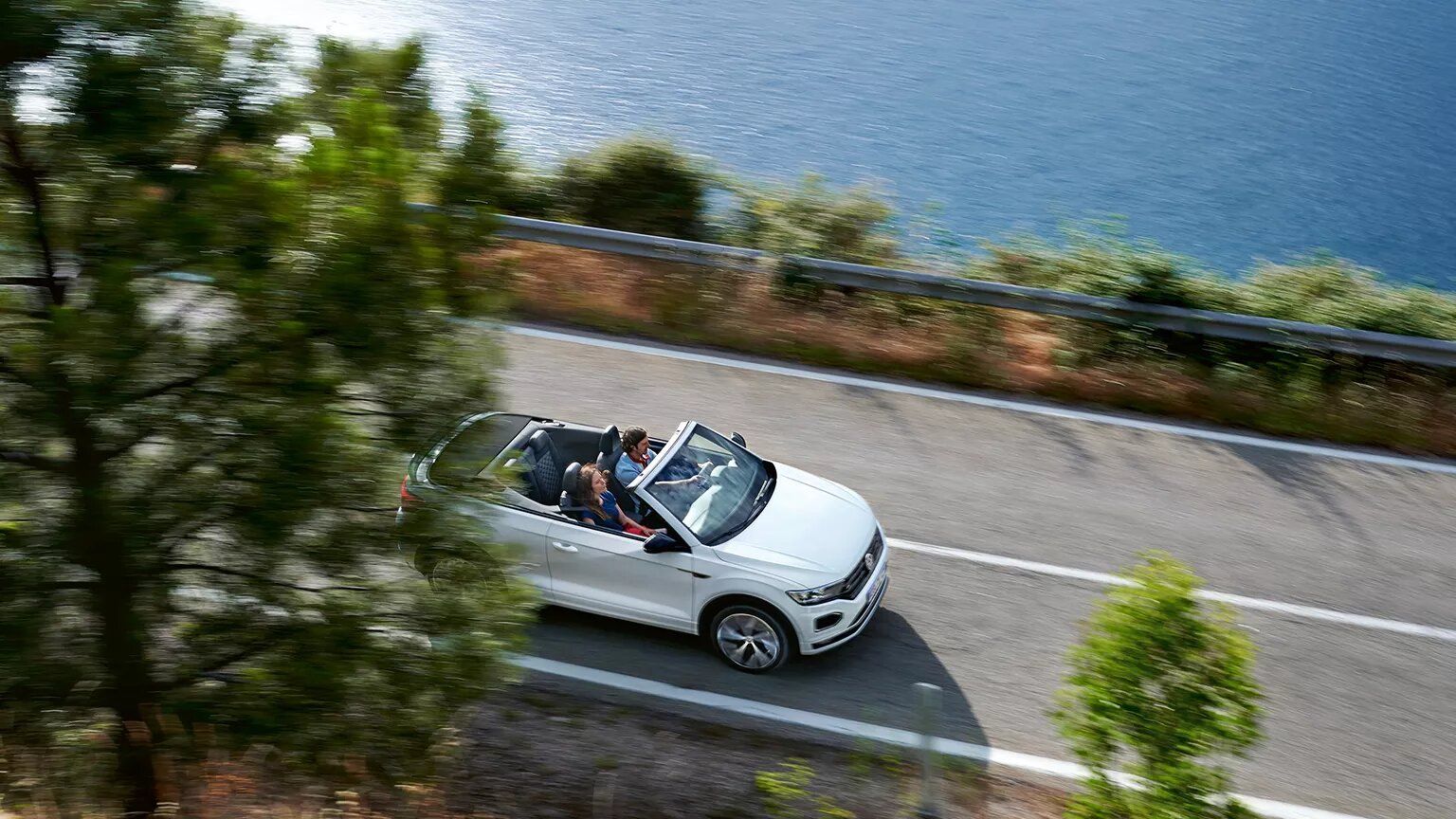Pogled iz ptičje perspektive: VW T-Roc Cabriolet vozi po regionalni cesti