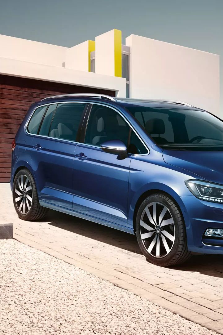 Modri VW Touran parkiran pred enodružinsko hišo