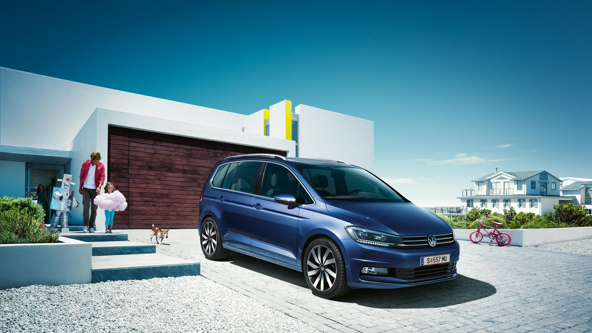 Modri VW Touran parkiran pred enodružinsko hišo