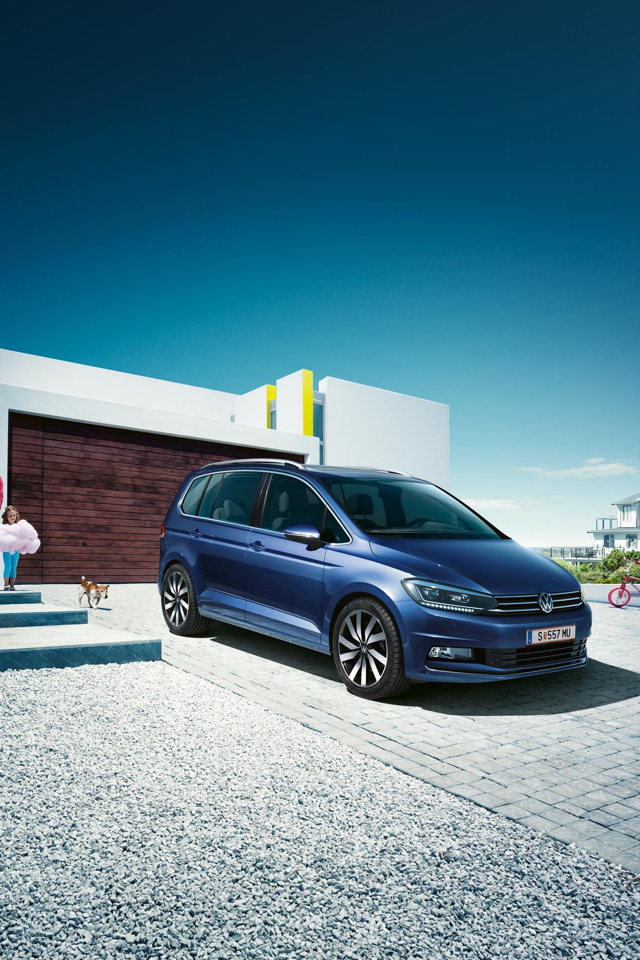Modri VW Touran parkiran pred enodružinsko hišo