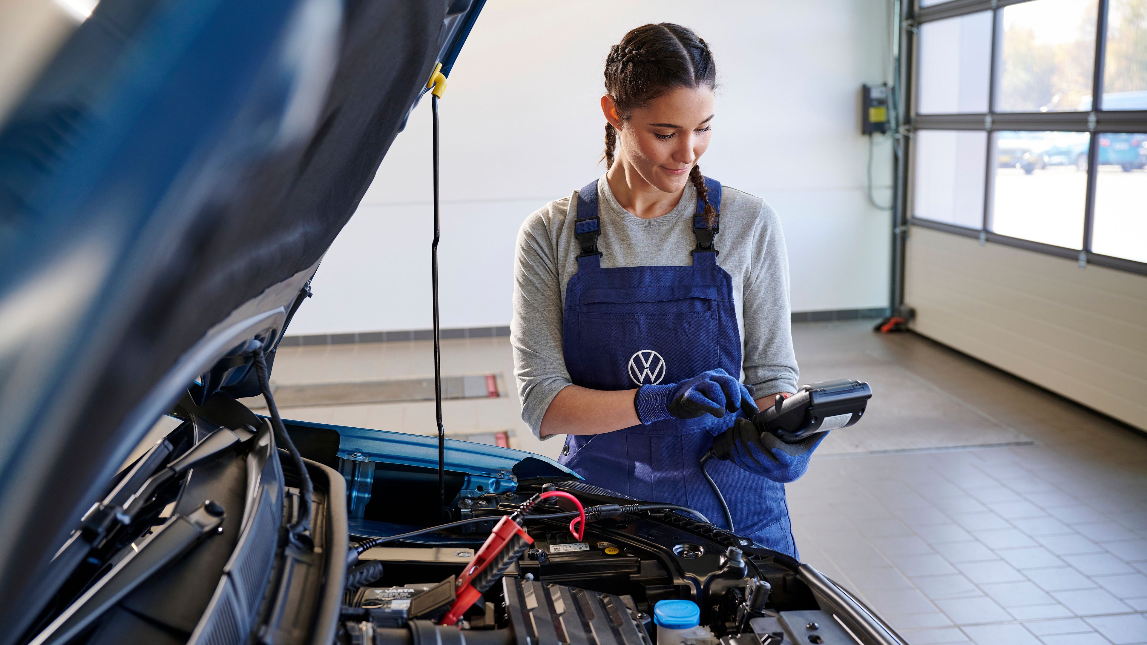Volkswagen ID.3 fährt am Tag an einem Gebäude vorbei, Ansicht von schräg hinten