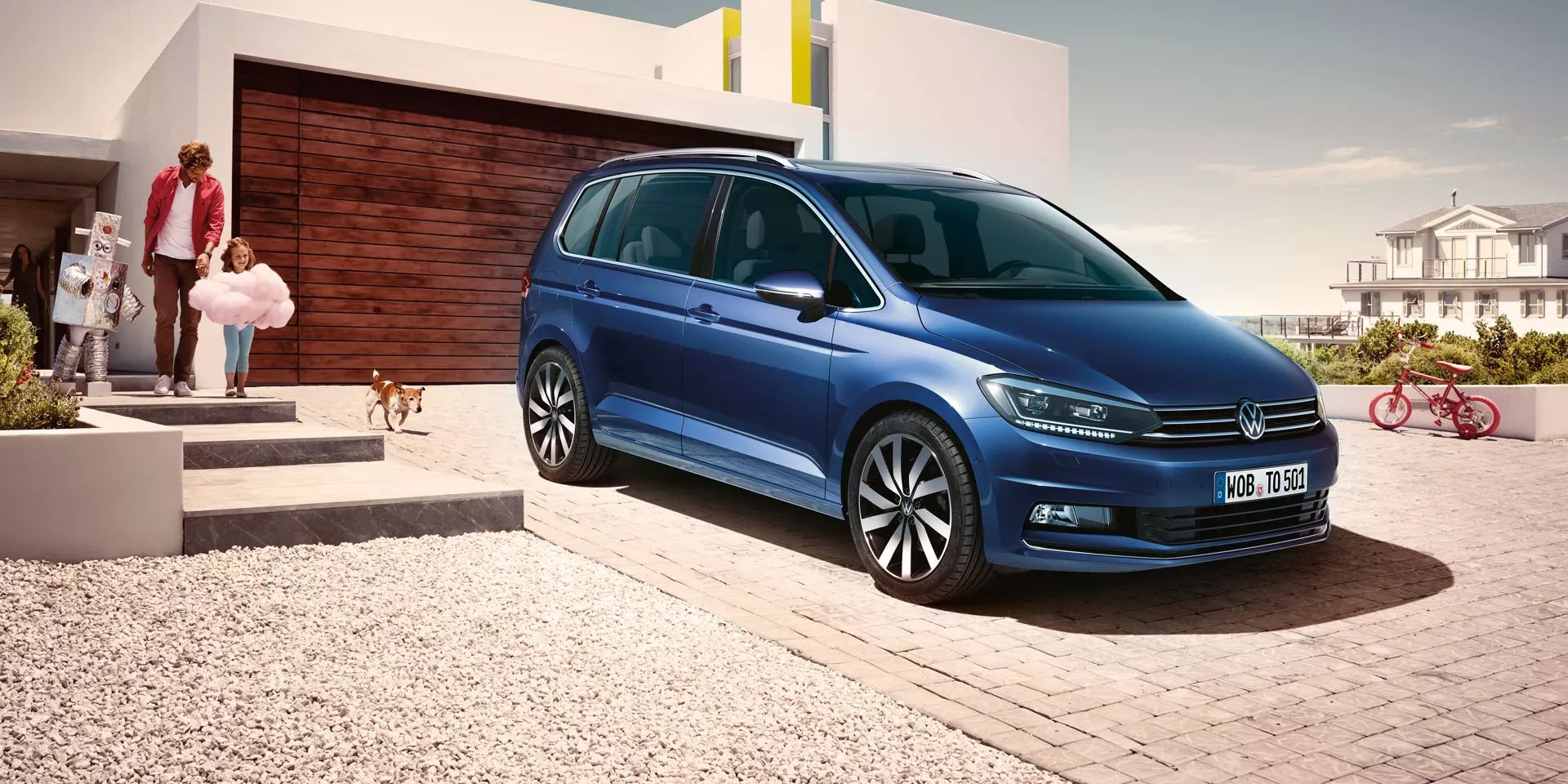 Modri VW Touran parkiran pred enodružinsko hišo