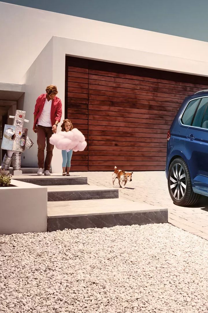 Modri VW Touran parkiran pred enodružinsko hišo