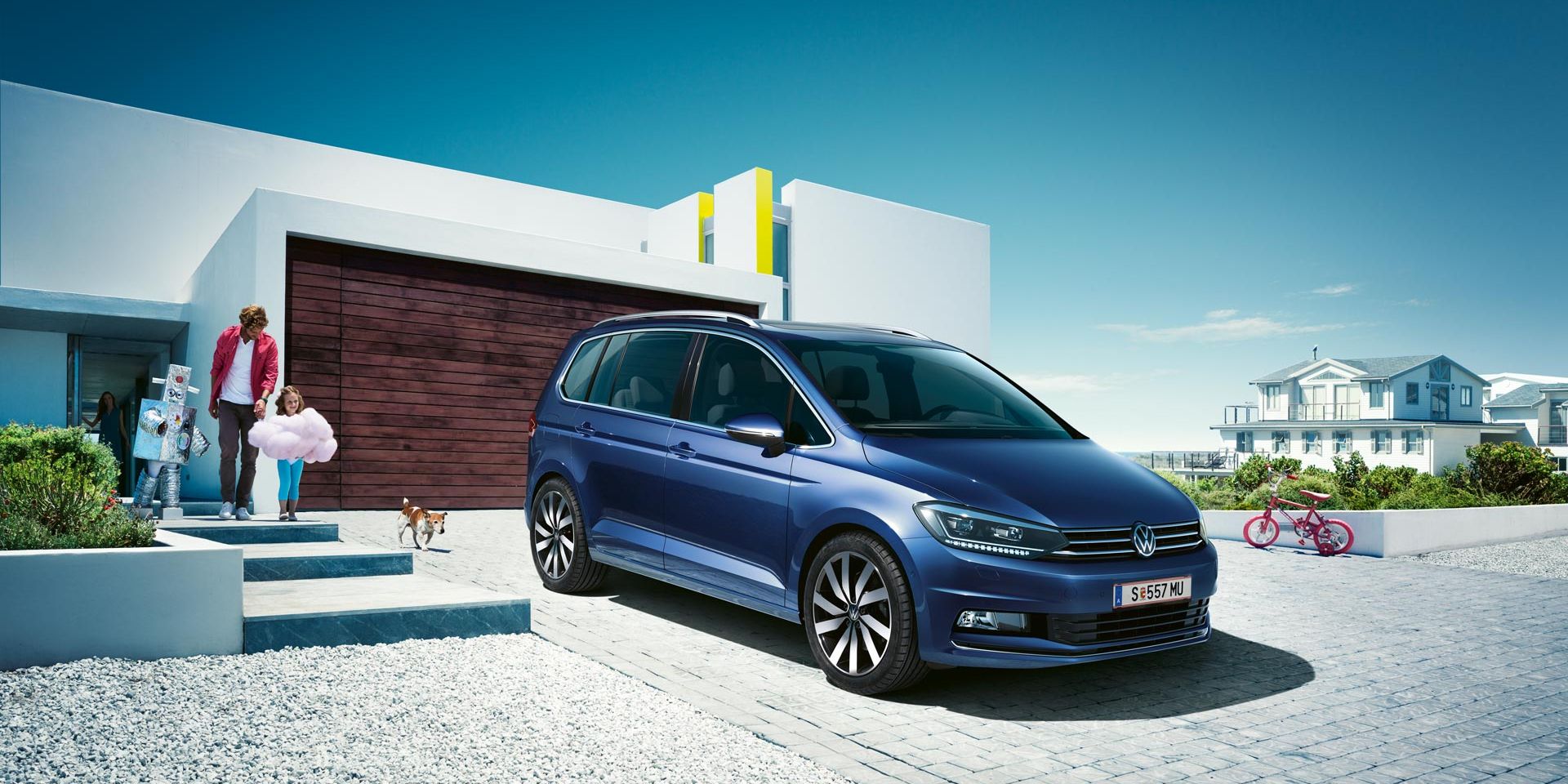 Modri VW Touran parkiran pred enodružinsko hišo