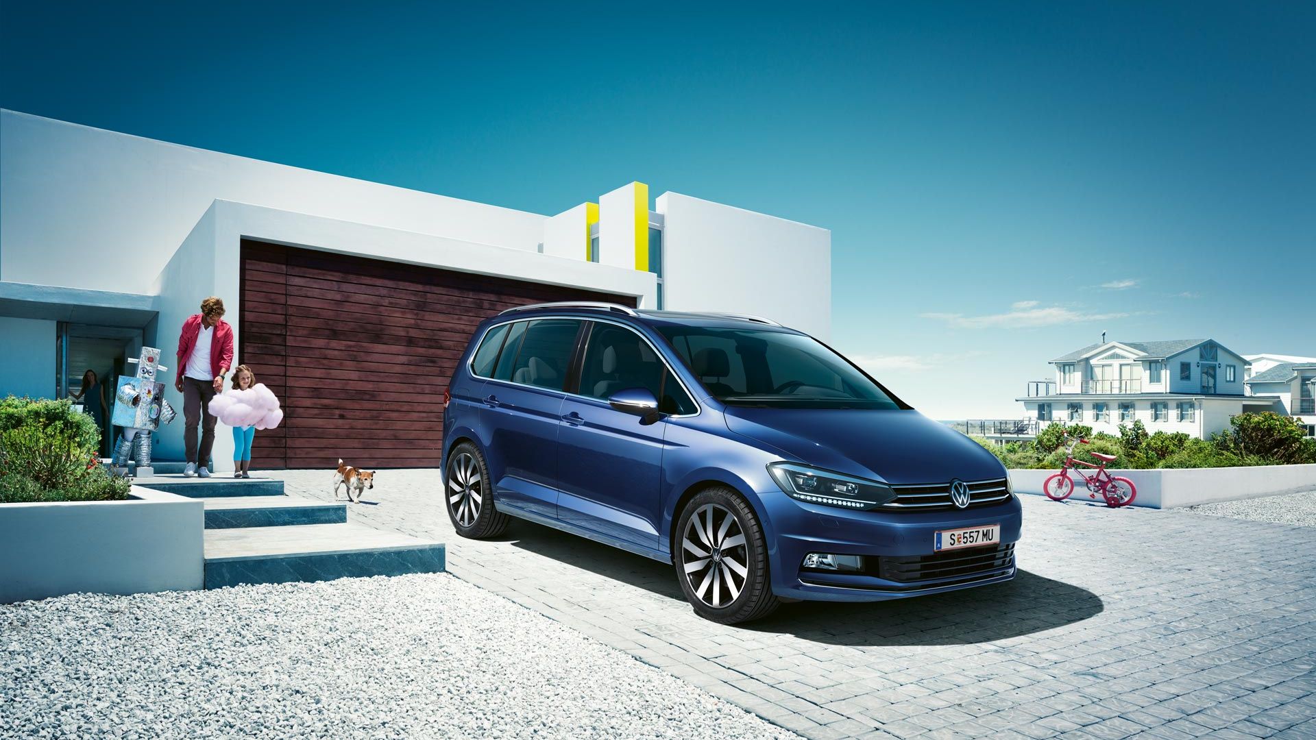 Modri VW Touran parkiran pred enodružinsko hišo