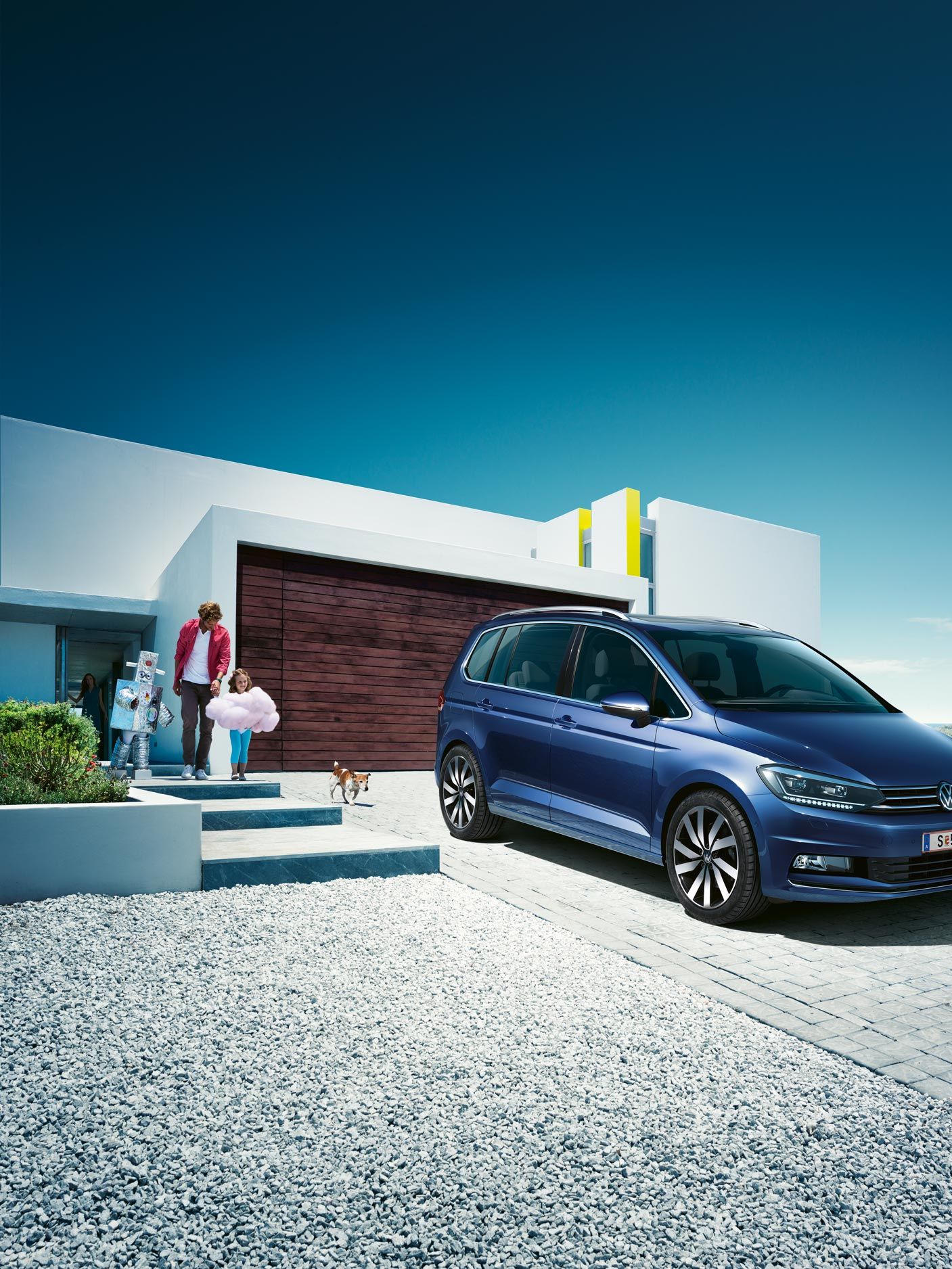 Modri VW Touran parkiran pred enodružinsko hišo