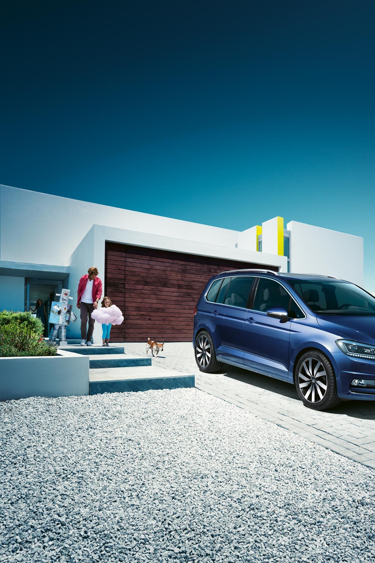 Modri VW Touran parkiran pred enodružinsko hišo