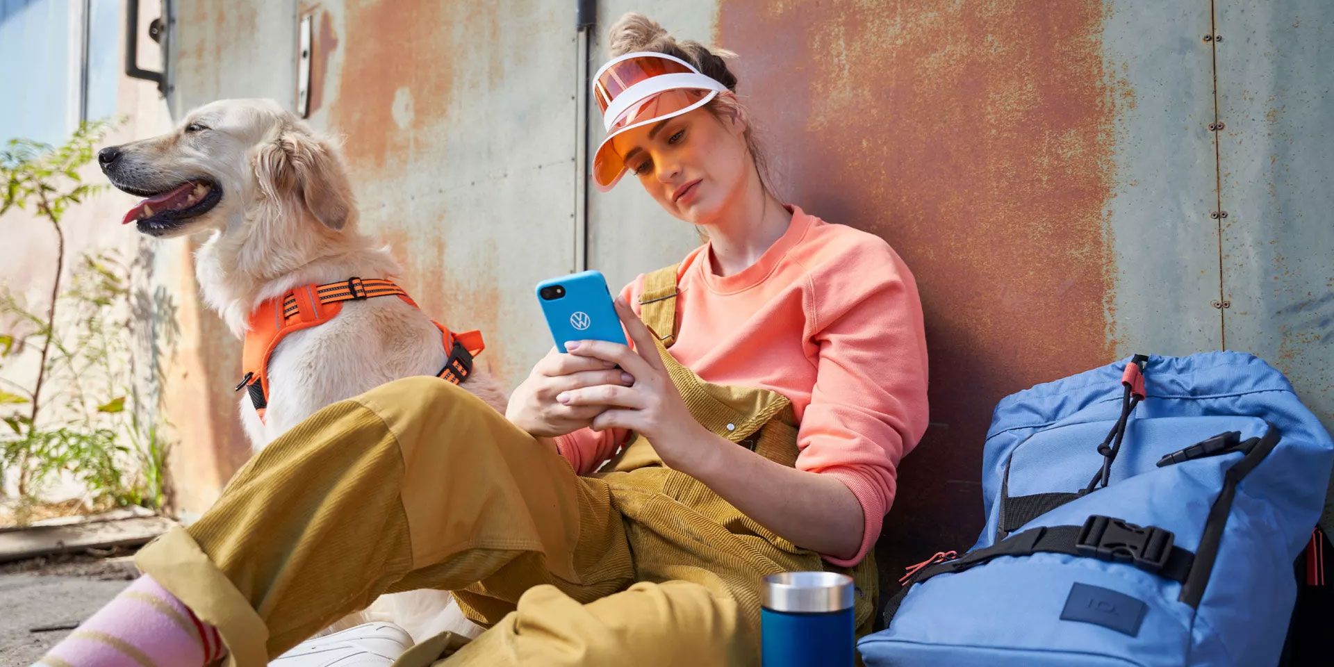 Eine Frau blickt auf ihr Smartphone, ein Hund ist bei ihr