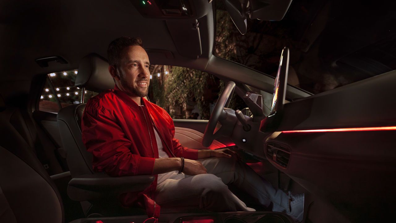 Mann in roter Jacke sitzt in seinem Volkswagen