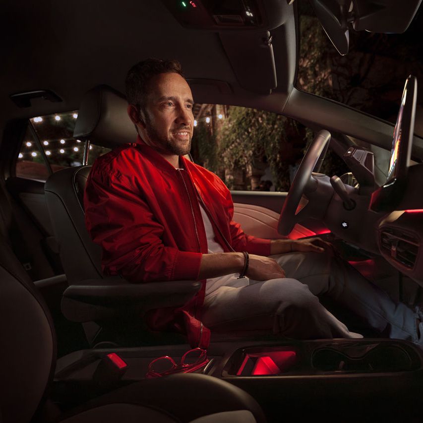 Mann in roter Jacke sitzt in seinem Volkswagen