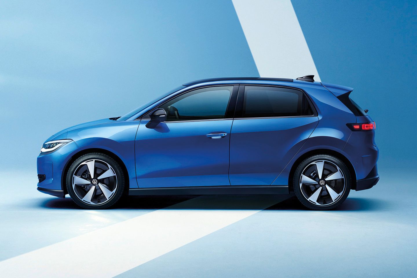 Moderen moder Volkswagen ID. Polo s petimi vrati je prikazan s strani na svetlo modrem ozadju. Avto ima športna platišča, zatemnjena okna in preprosto, aerodinamično obliko. Svetel diagonalni pas v ozadju poudari silhueto vozila.