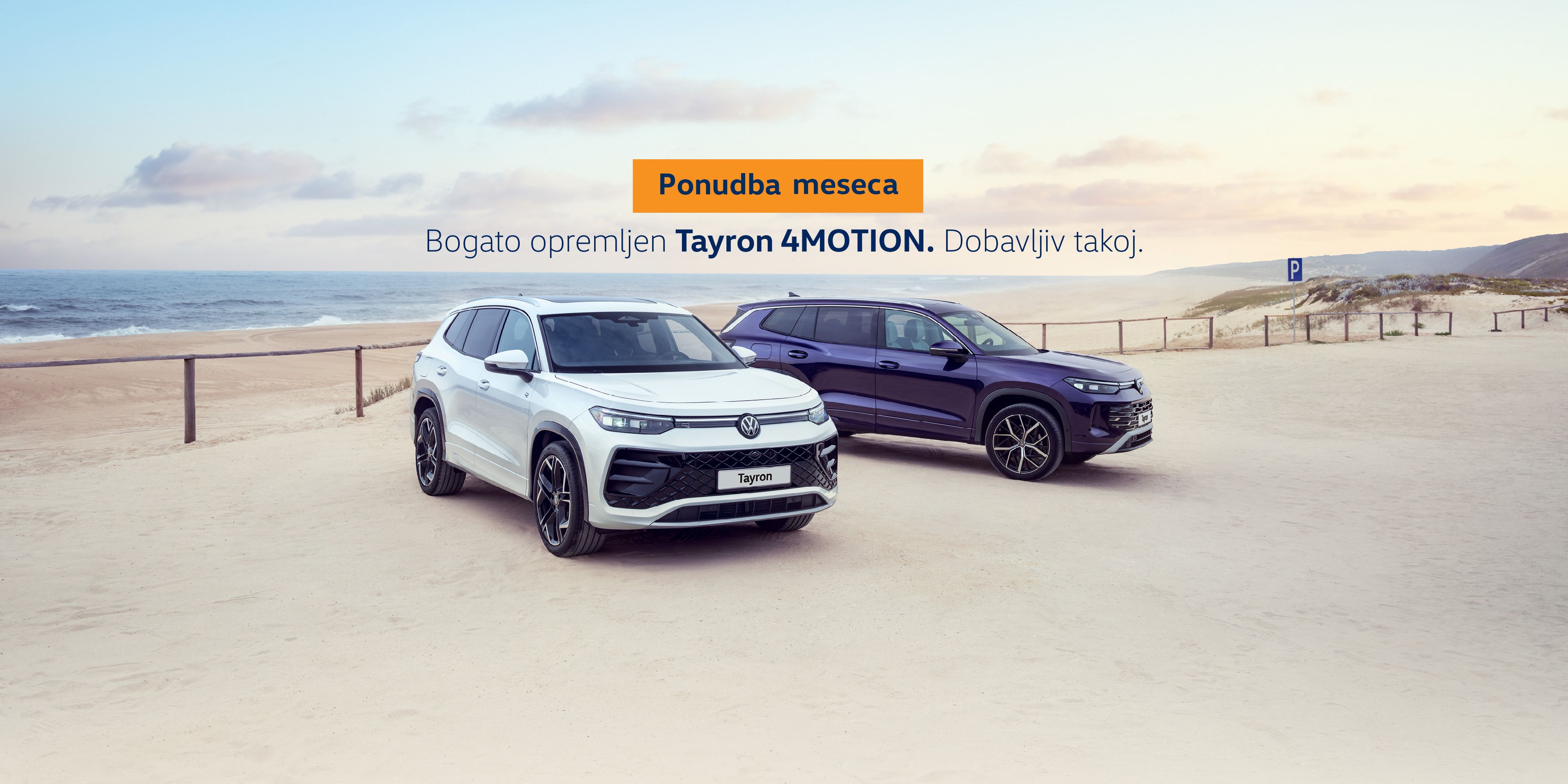 Oglasna fotografija dveh športnih terencev Volkswagen Tayron 4MOTION, parkiranih na peščenem parkirišču ob plaži, eden bel in eden temno moder. V ozadju so sipine, morje in modro nebo. Na sredini slike je napis v slovenščini, ki izpostavlja »Ponudbo meseca« in takojšnjo dobavljivost bogato opremljenega modela.