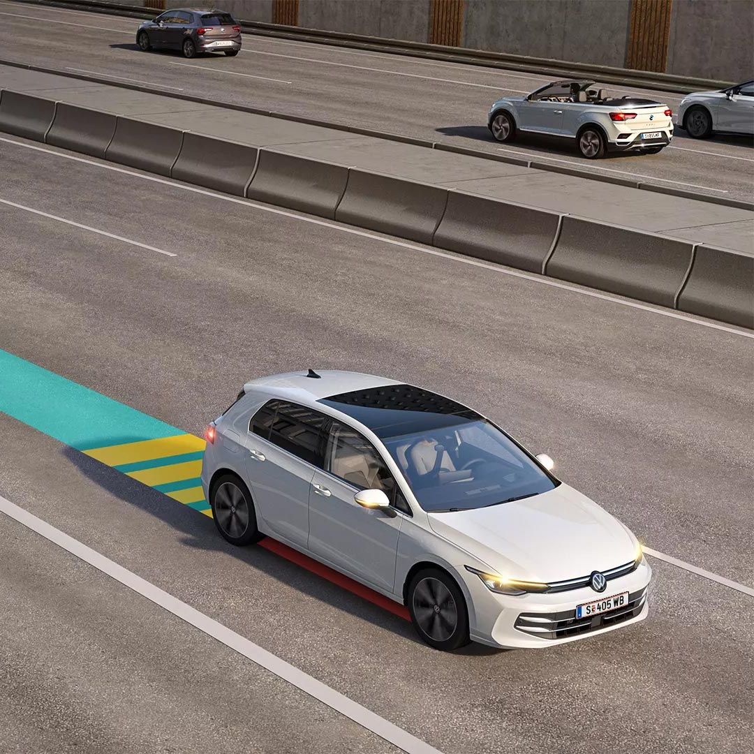 Bel VW Golf med vožnjo v mestnem prometu. Vključen je sistem Emergency Assist, katerega delovanje je shematsko prikazano na sliki.