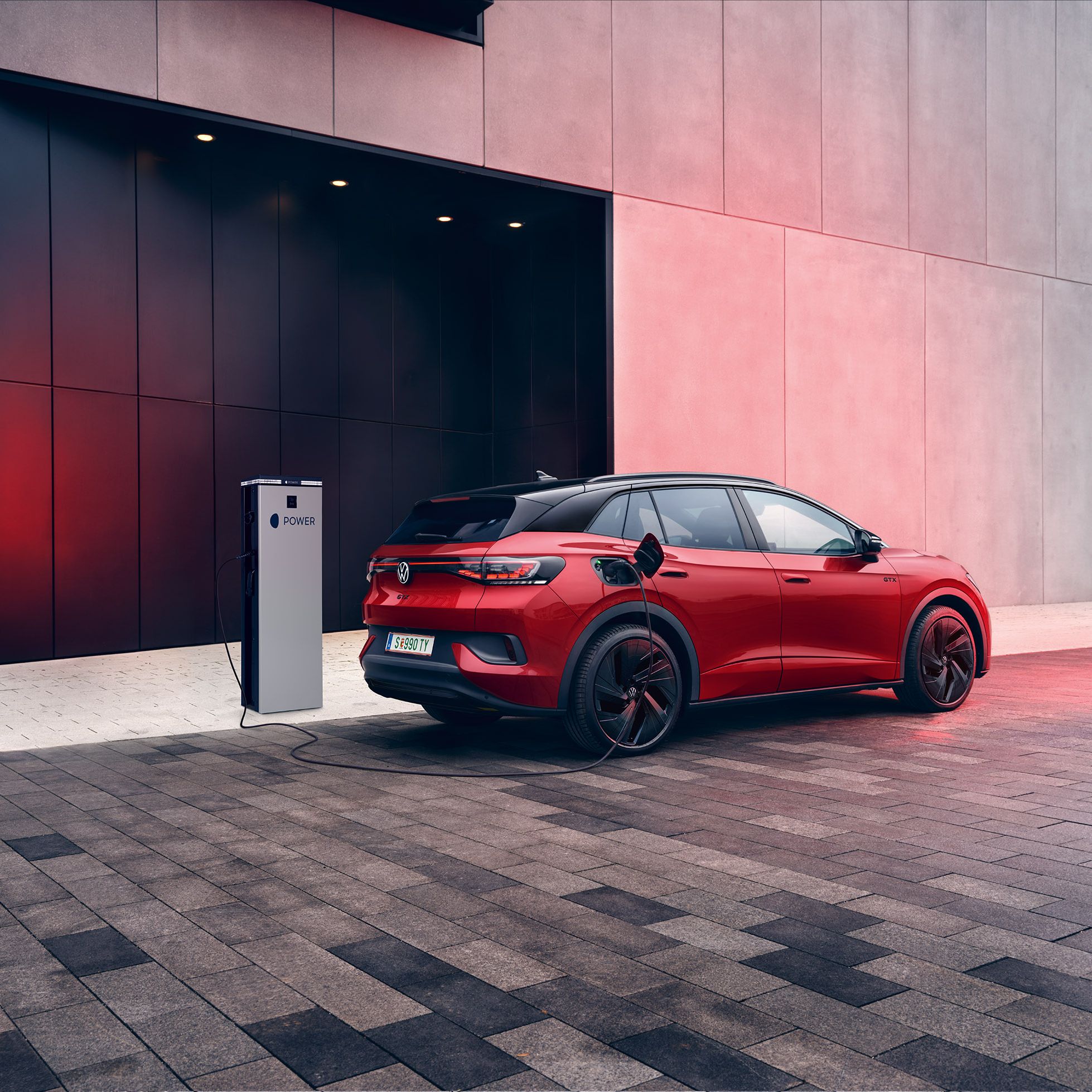 Heckansicht eines VW ID.4 GTX der gerade an MOON Ladestation geladen wird