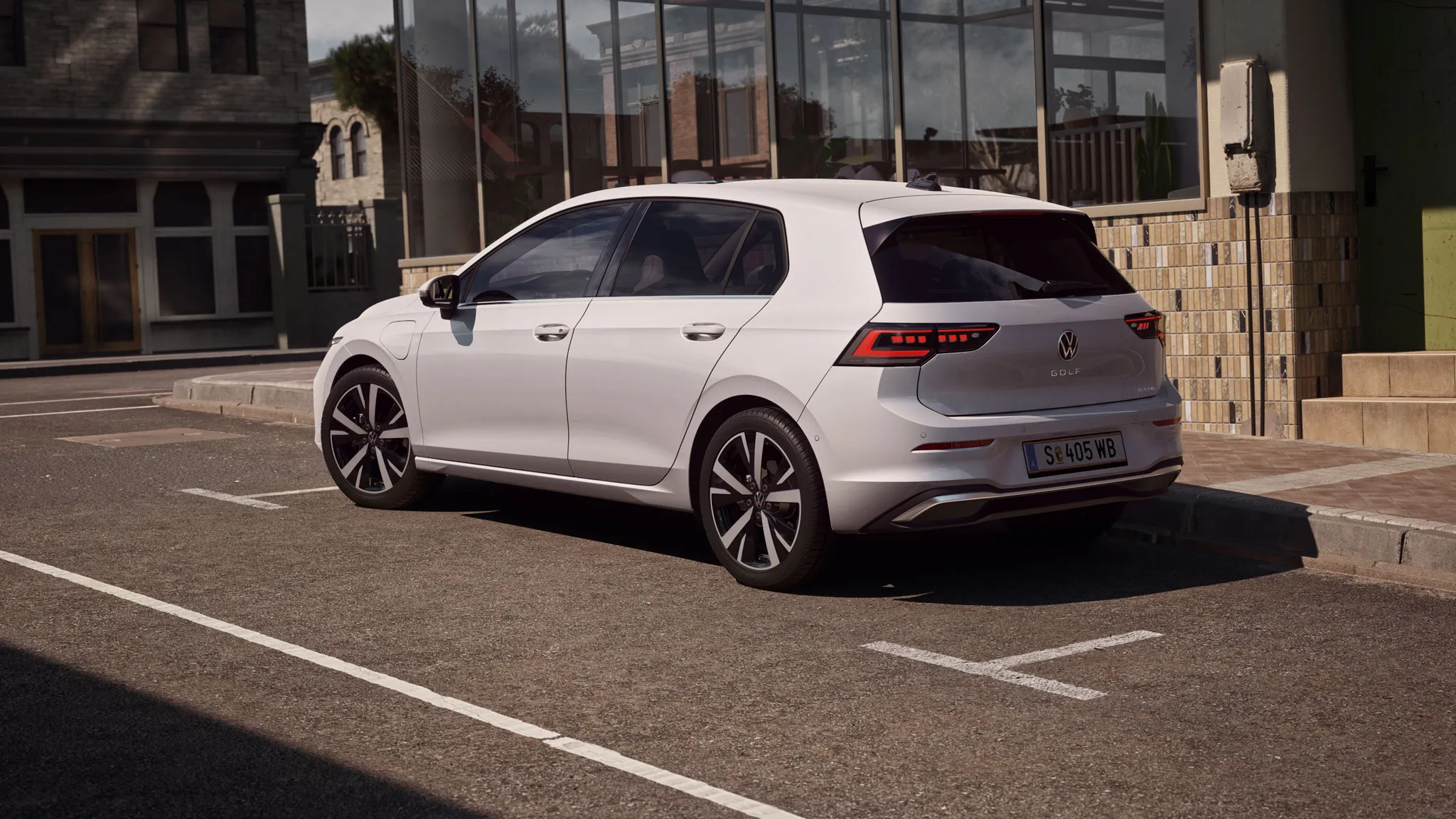 Stranska silhueta VW Golfa, ki parkira poleg restavracije. Moški se premika od vrat restavracije proti vozilu.