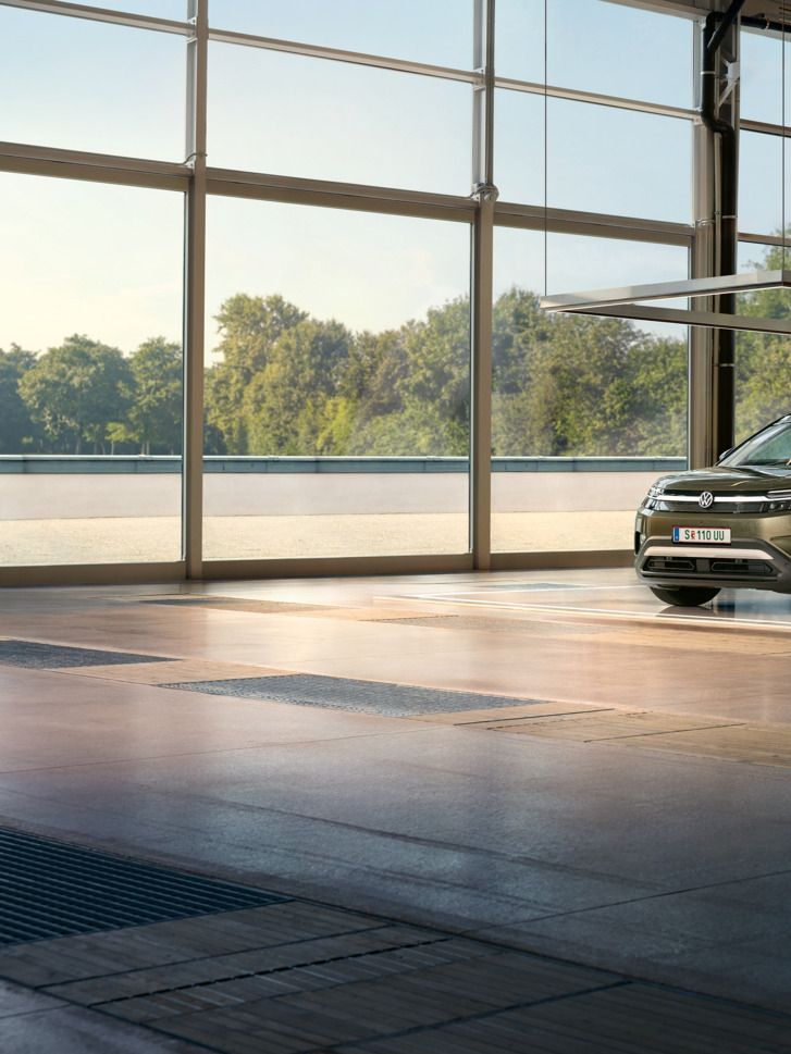 VW ID. Cross stoji v minimalistično opremljenem oblikovalskem studiu, ob njem pa poskakuje vznemirjen moški in se pogovarja z inženirko.