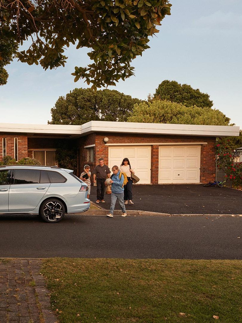Seitenansicht eines VW Golf Variant in der Farbe Ice Blue Metallic geparkt vor Einfamilienhaus