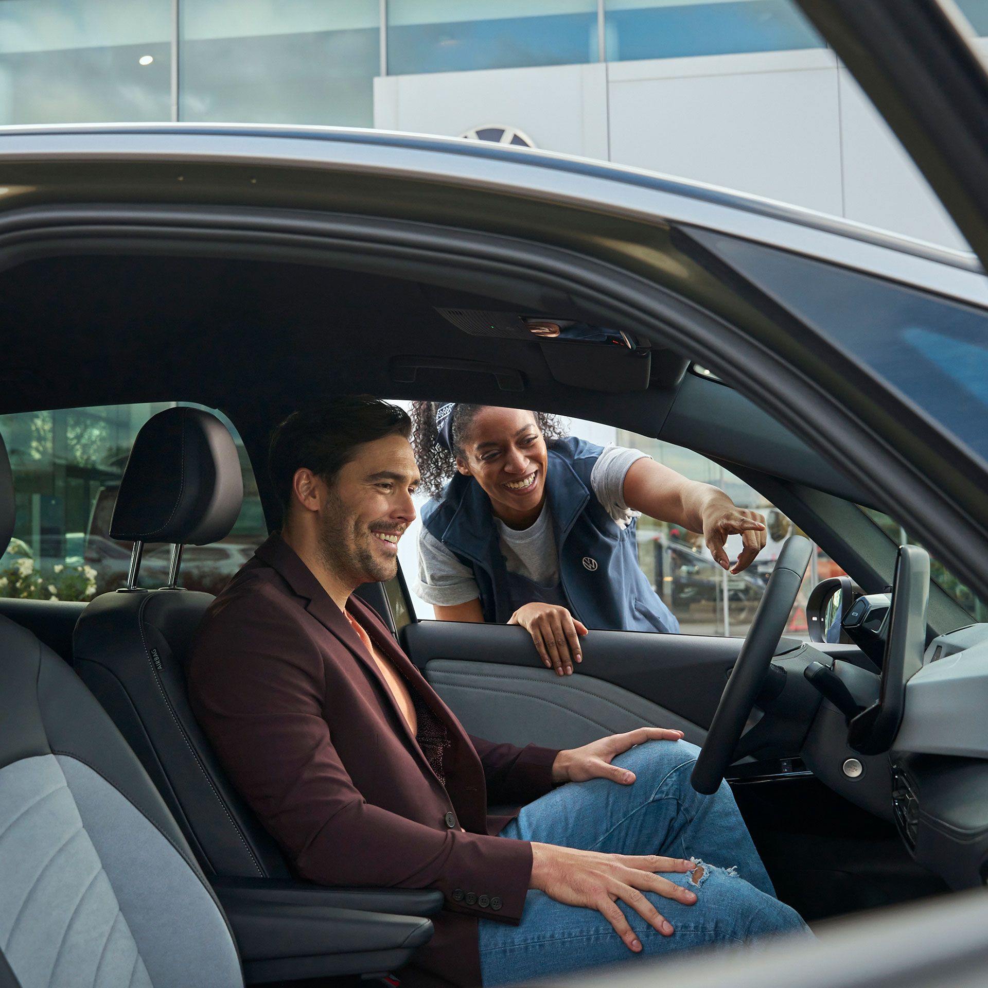 Eine Volkswagen Technikerin erklärt einem Kunden das Display in einem ID.