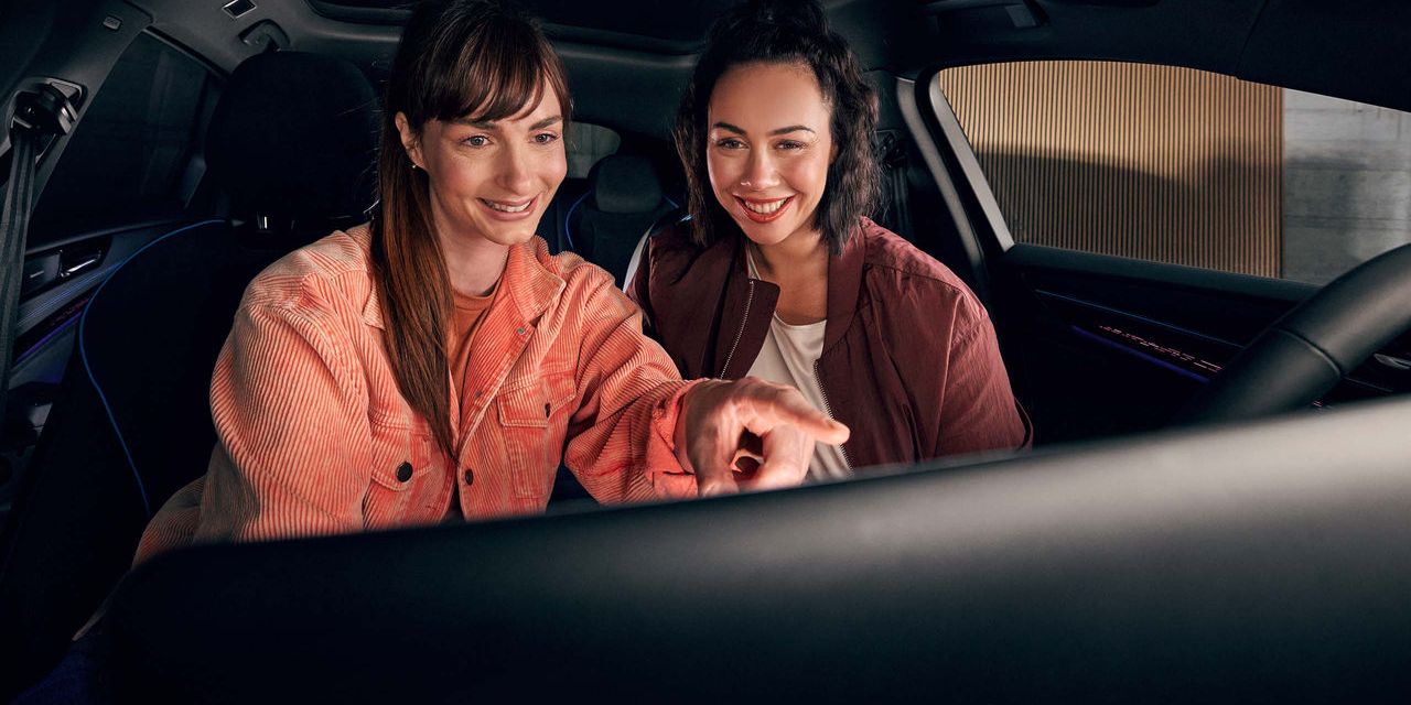 Zwei Frauen benutzen das Infotainment-System im VW Auto