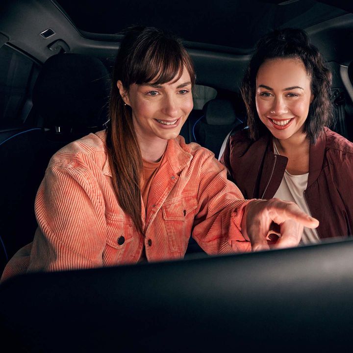 Zwei Frauen benutzen das Infotainment-System im VW Auto