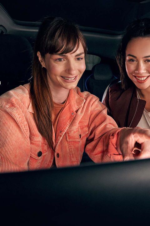 Zwei Frauen benutzen das Infotainment-System im VW Auto