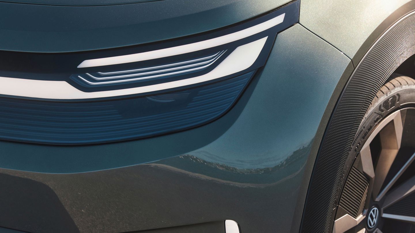 Bližnji posnetek avtomobilskega žarometa in dela blatnika sodobnega vozila. Žaromet ima elegantno, ukrivljeno LED zasnovo. 