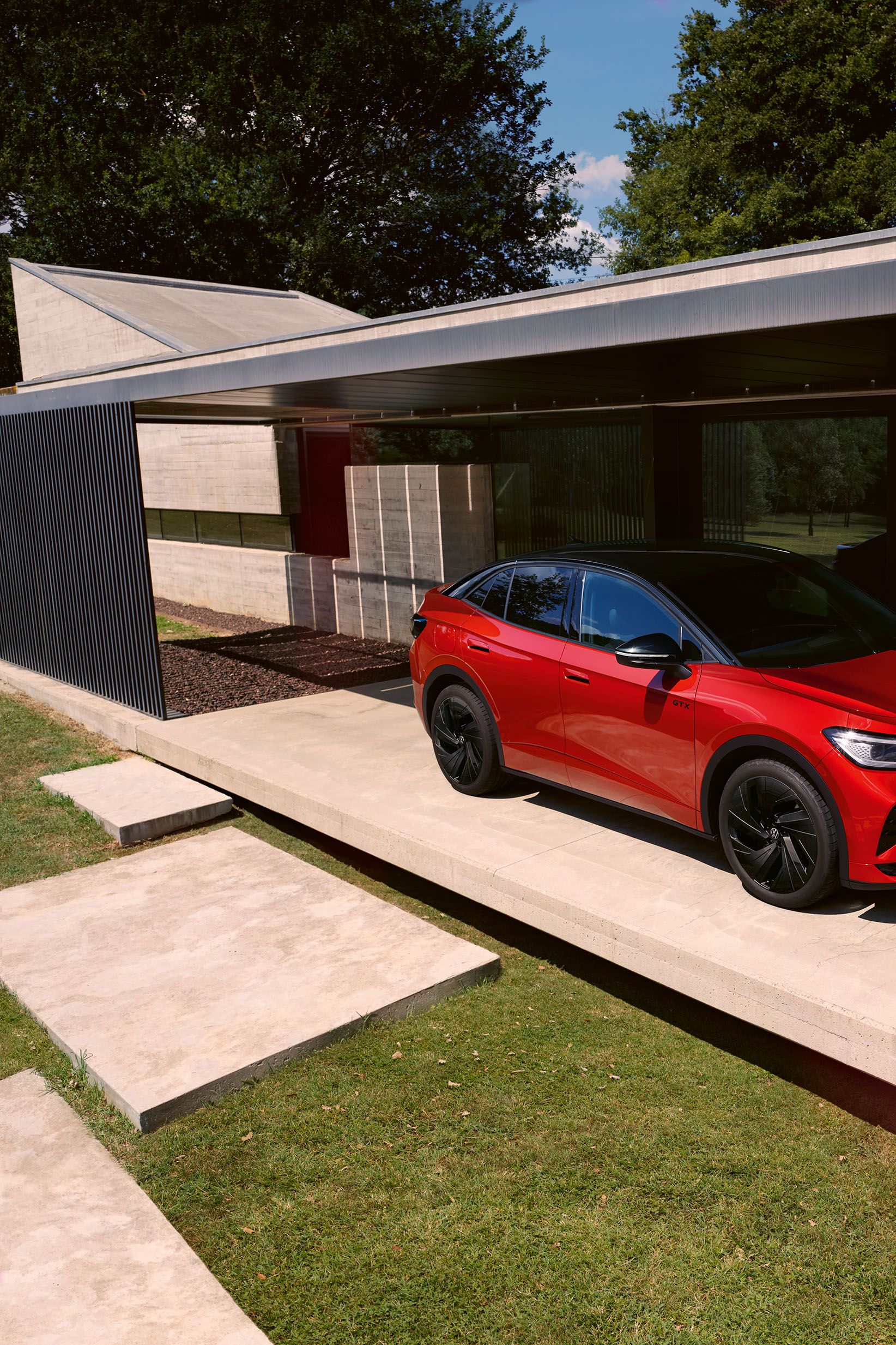 Roter VW ID.5 GTX parkend vor einem Haus. Ein Mann geht vorbei.