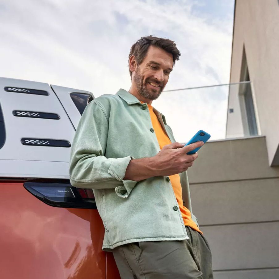 Im Mann mit Smartphone lehnt an einem ID. Buzz