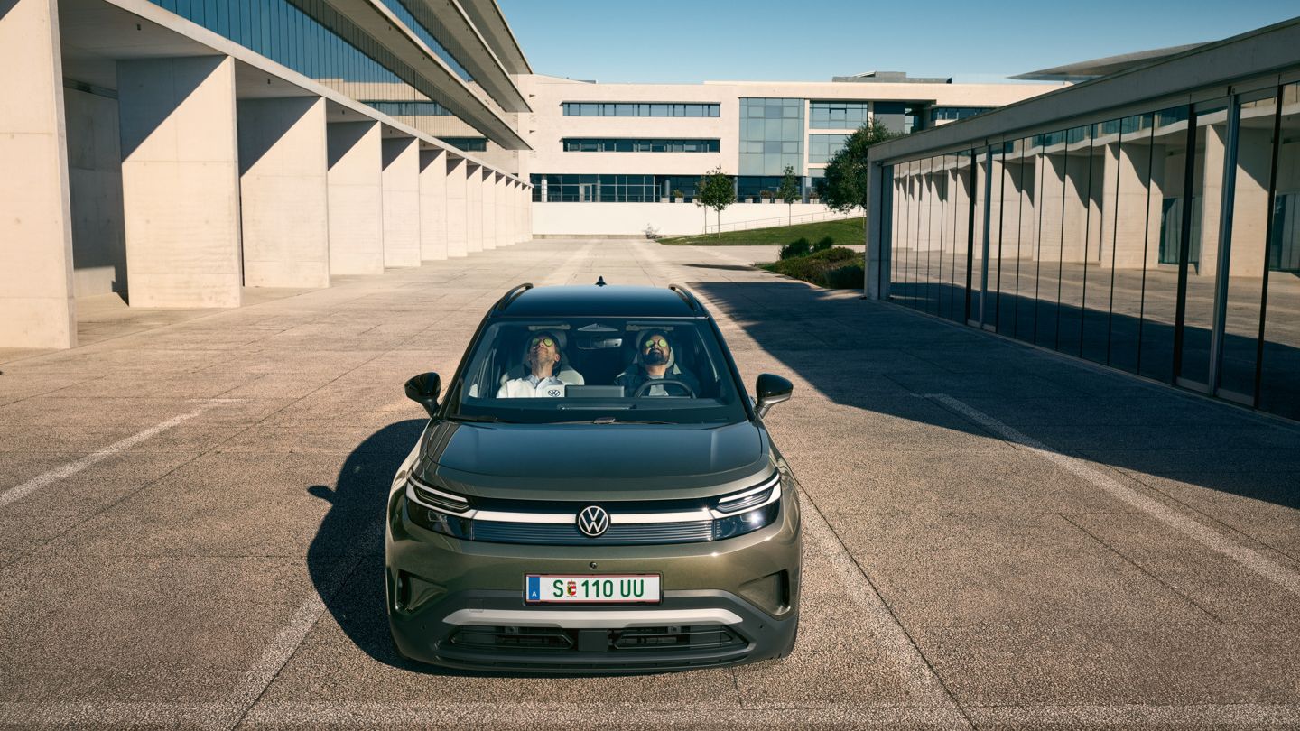 Dva moška sedita udobno naslonjena na sprednjih sedežih VW ID. Crossa in imata zaprte oči. 