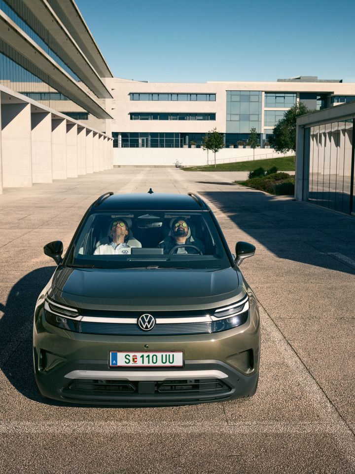 Dva moška sedita udobno naslonjena na sprednjih sedežih VW ID. Crossa in imata zaprte oči. 