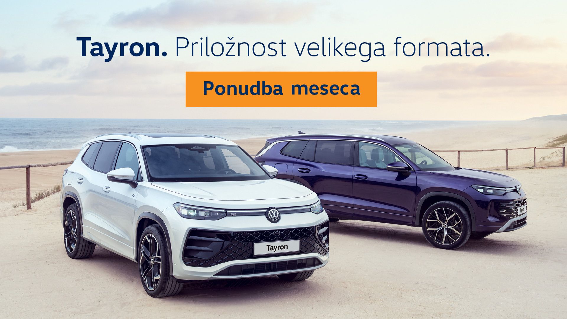 Oglas prikazuje dva Volkswagen Tayrona parkirana ob peščeni plaži, enega belega v ospredju in enega temno modrega v ozadju. V zgornjem delu je napis “Tayron. Priložnost velikega formata.”, na oranžnem gumbu pa piše “Ponudba meseca”.