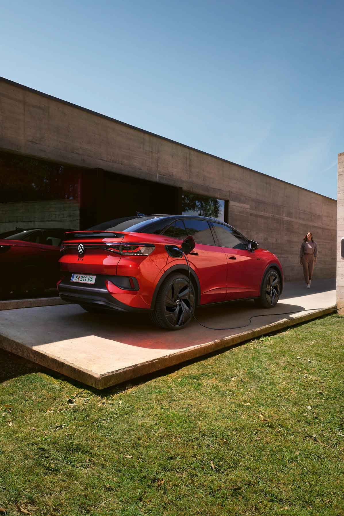 Roter VW ID.5 GTX wird vor Gebäude geladen