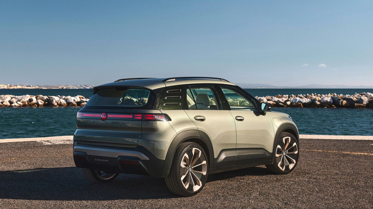 Zeleni VW ID. Cross stoji ob obalni cesti z razgledom na morje in modro nebo brez oblakov. 