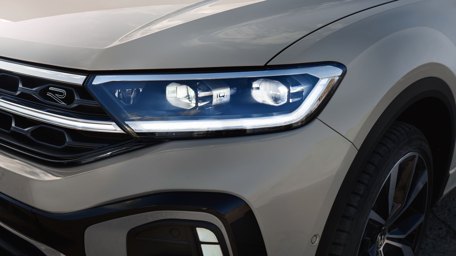 Sprednji del belega VW T-Roca R-Line, detajlni posnetek žarometov IQ.LIGHT.