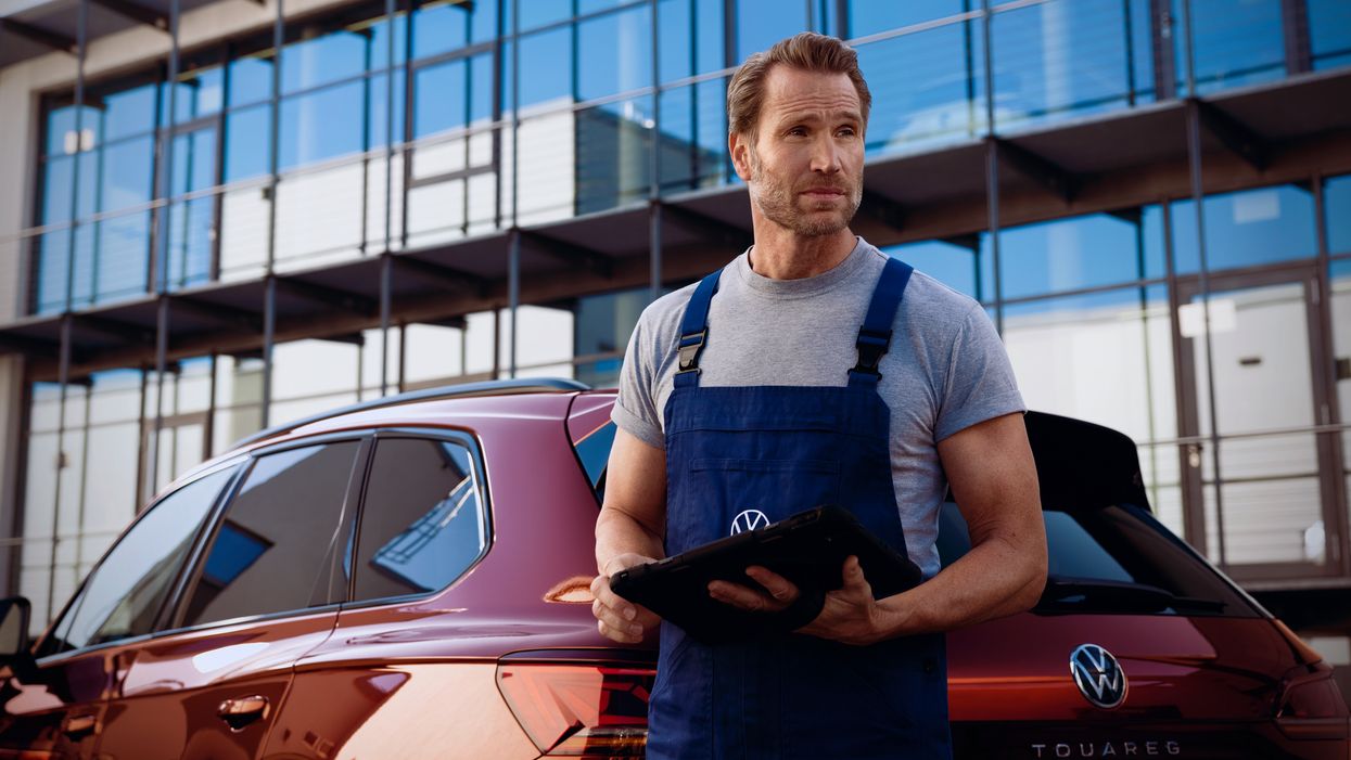 VW Service Techniker vor einem VW Touareg